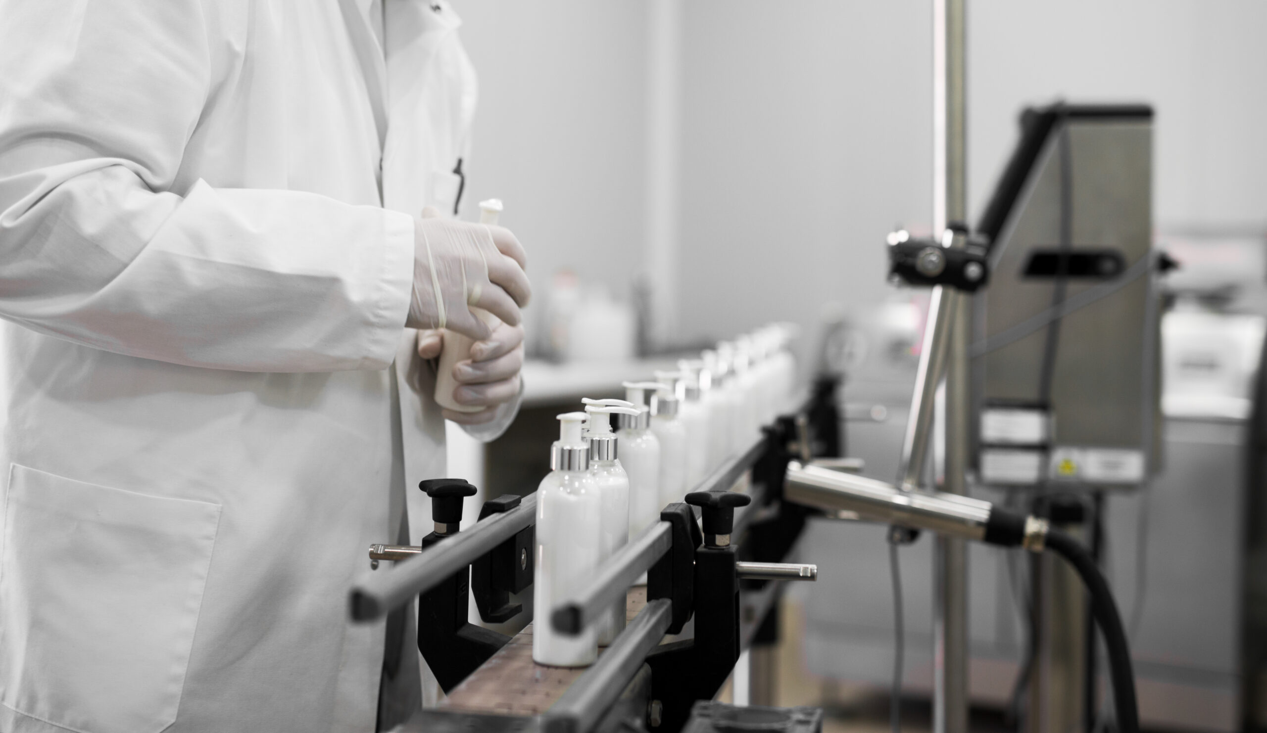 Cosmetics fabric worker taking one liquid soap from a row on a fabric line.